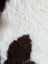 White and brown fluffy tibet highland spotted sheepskin with plush textured surface in size 41.5 by 25.5 inches