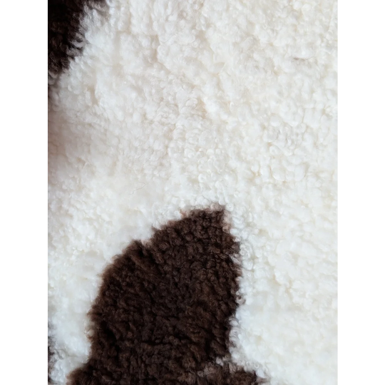 White and brown fluffy tibet highland spotted sheepskin with plush textured surface in size 41.5 by 25.5 inches