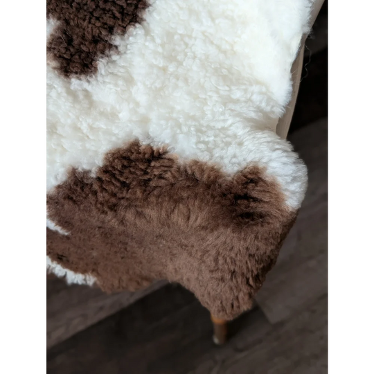 A plush tibet highland spotted sheepskin rug in white and brown spots perfect for cozy home decor