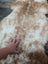A soft fluffy grade a tibet highland spotted sheepskin rug in cream and light brown perfect for cozy decor