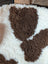 A plush cream and brown highland spotted sheepskin blanket with a soft curly texture perfect for cozy use