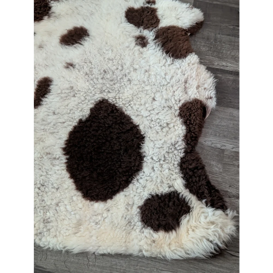 A cream highland spotted sheepskin rug with irregular dark brown spots from tibet highland spotted grade a collection