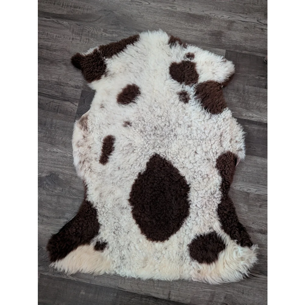 A plush white and brown highland spotted tibet highland spotted sheepskin rug with soft fluffy texture and grade a quality
