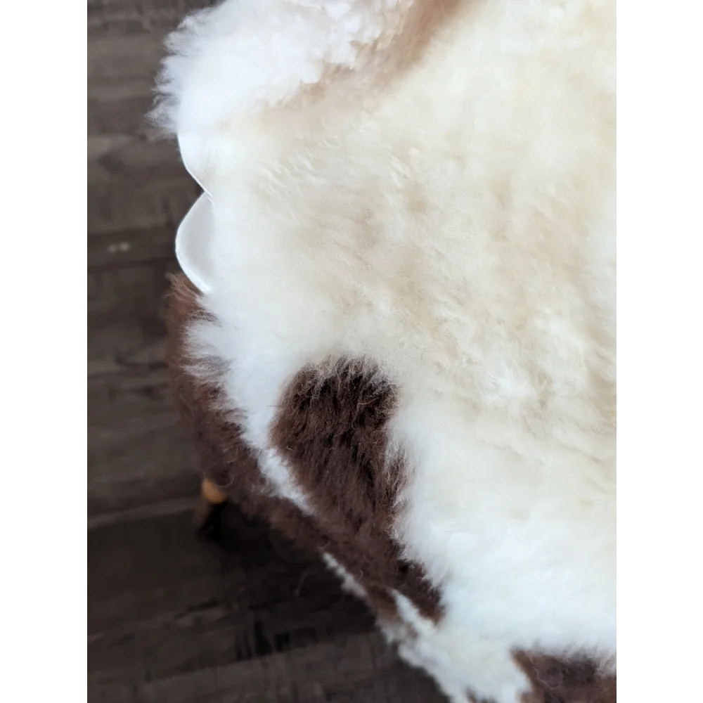A plush cream and brown tibet highland spotted sheepskin throw with soft fluffy texture perfect for cozy spaces