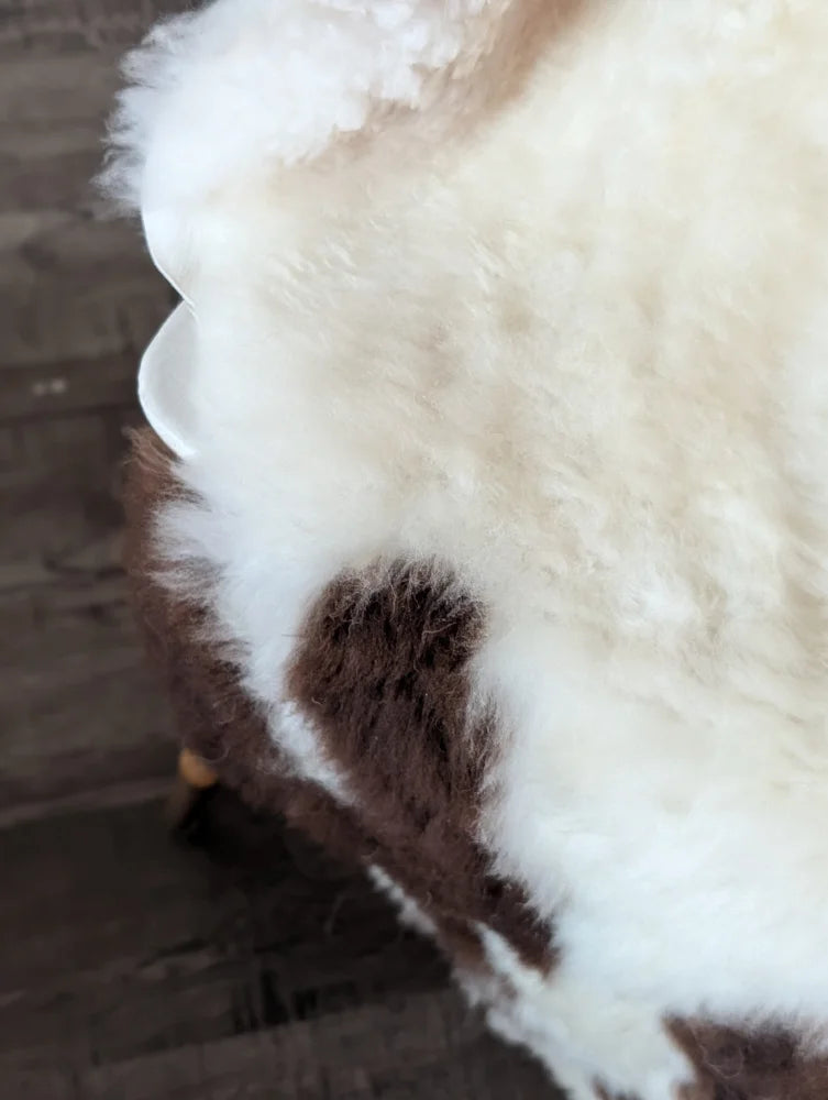 A plush cream and brown tibet highland spotted sheepskin throw with soft fluffy texture perfect for cozy spaces