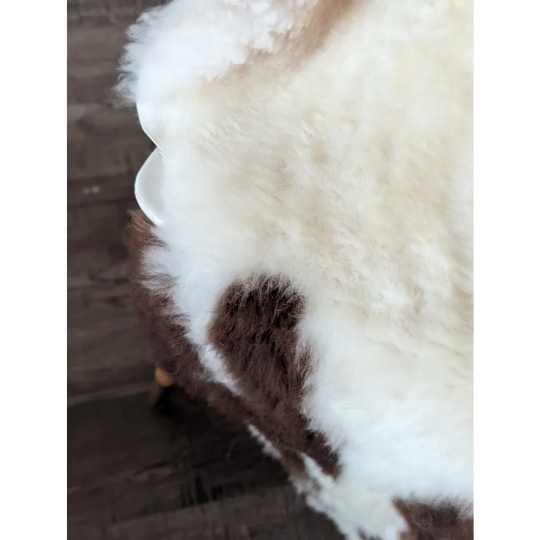A plush cream and brown tibet highland spotted sheepskin throw with soft fluffy texture perfect for cozy spaces