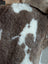 Brown and white tibet highland spotted sheepskin with plush textured surface perfect for cozy decor or rugs