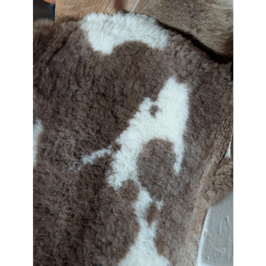 Brown and white tibet highland spotted sheepskin with plush textured surface perfect for cozy decor or rugs