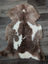 A plush tibet highland spotted sheepskin rug in soft brown and white spotted pattern measuring 41.5 by 26 inches