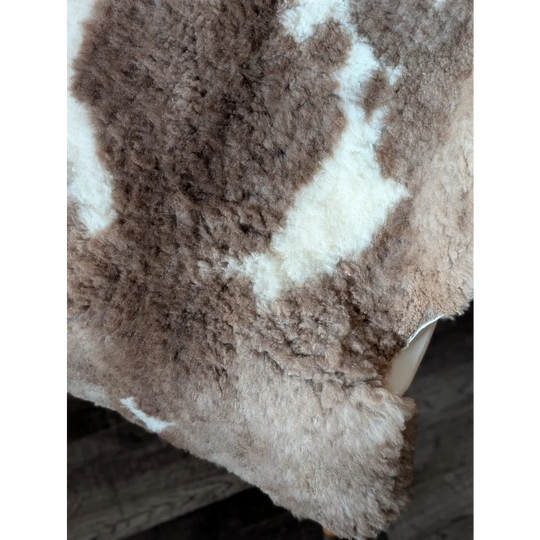 A plush tibet highland spotted sheepskin throw in soft brown and white with dense fluffy texture 41.5 x 26 inches