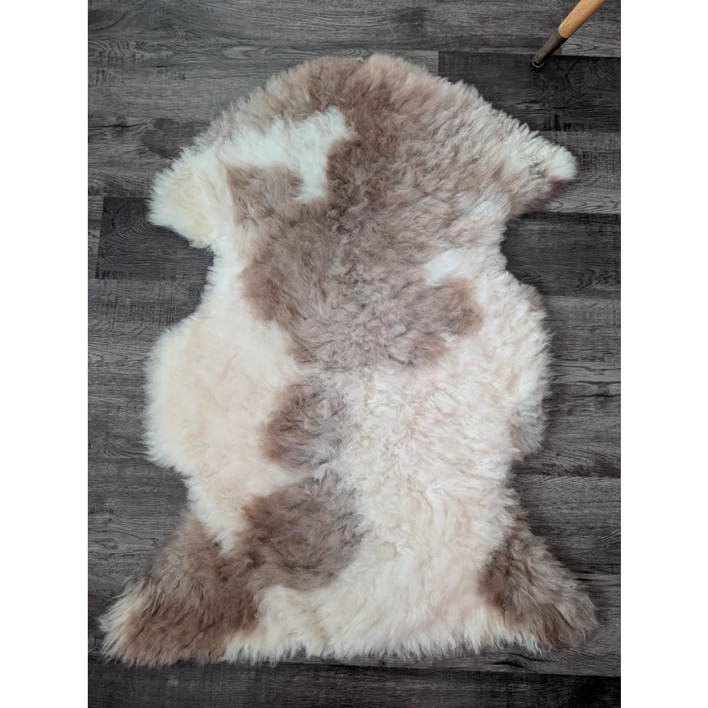 A soft fluffy tibet highland spotted sheepskin rug with creamy white and light brown patches for cozy decor
