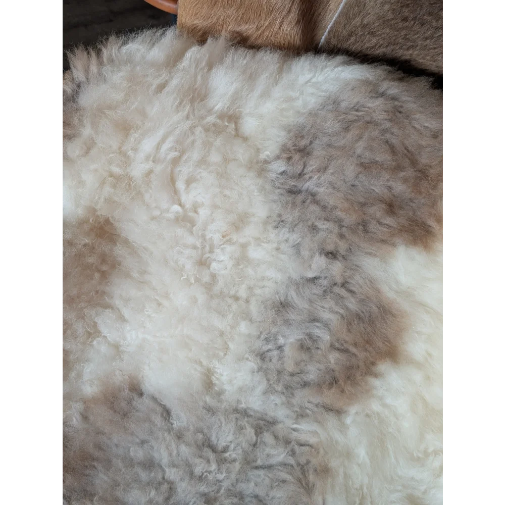 A plush tibet highland spotted sheepskin rug with soft white and light brown mottled texture grade a 40.5 x 26 inches