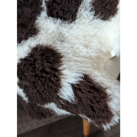 A plush tibet highland spotted sheepskin rug in rich brown and creamy white perfect for cozy decor