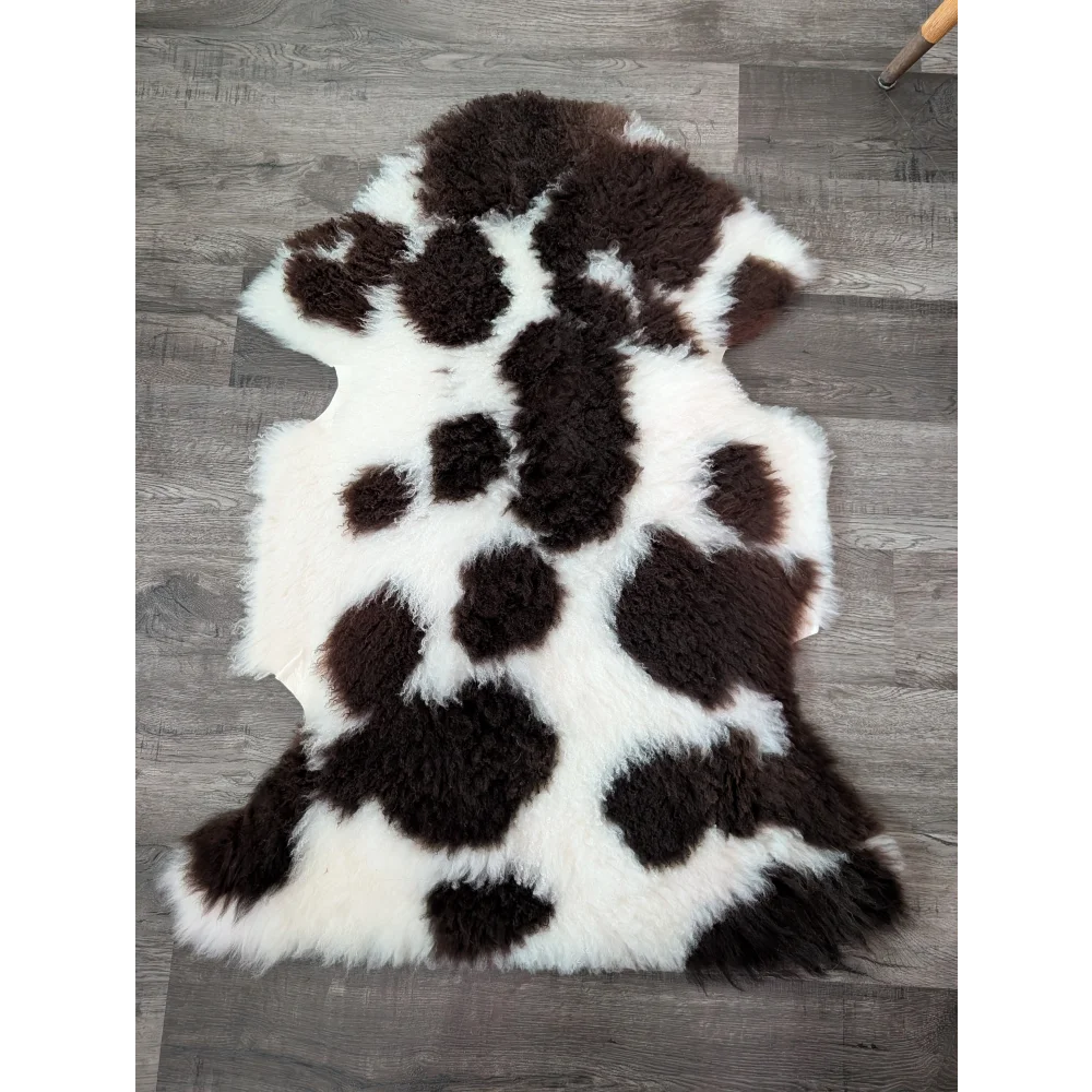 A plush natural tibet highland spotted sheepskin rug in black and white perfect for cozy home decor