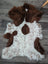 A plush fluffy brown and white highland spotted sheepskin rug with a natural irregular pattern from tibet highland spotted