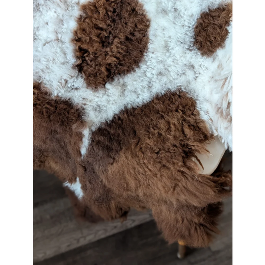 A plush 43x27 inch tibet highland spotted sheepskin rug with curly brown and white fur and soft texture