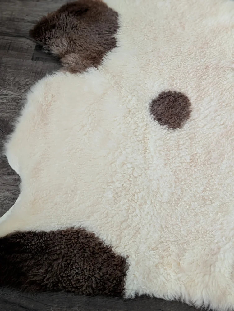 Cream-colored tibet highland spotted sheepskin rug with dark brown patches in 46 x 27 size for cozy decor