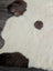 Cream-colored tibet highland spotted sheepskin rug with dark brown patches in 46 x 27 size for cozy decor