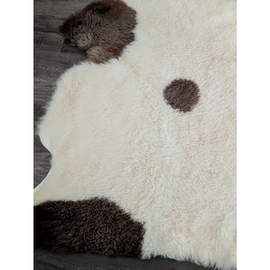 Cream-colored tibet highland spotted sheepskin rug with dark brown patches in 46 x 27 size for cozy decor