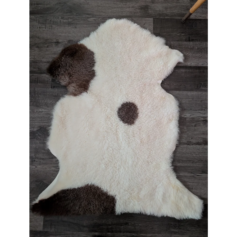 A plush tibet highland spotted sheepskin rug with creamy white base and rich brown patches in grade a quality