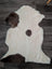 A plush tibet highland spotted sheepskin rug with creamy white base and rich brown patches in grade a quality