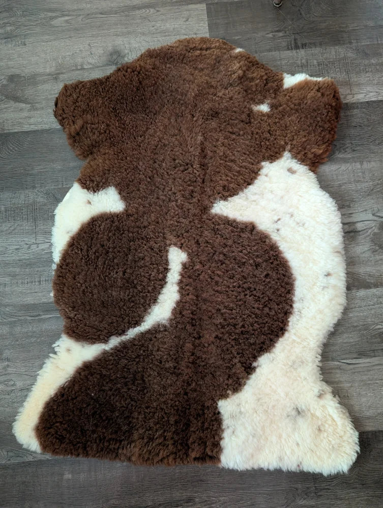 Brown and white highland spotted sheepskin rug made from tibet highland spotted grade a sheepskin measuring 41 x 26 inches