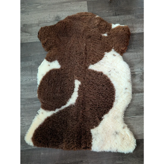 Brown and white highland spotted sheepskin rug made from tibet highland spotted grade a sheepskin measuring 41 x 26 inches