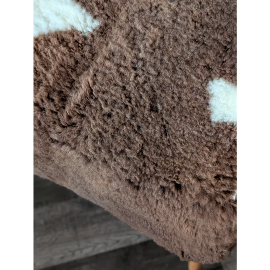 Brown tibet highland spotted sheepskin fabric with white patches for cozy home decor or rugs
