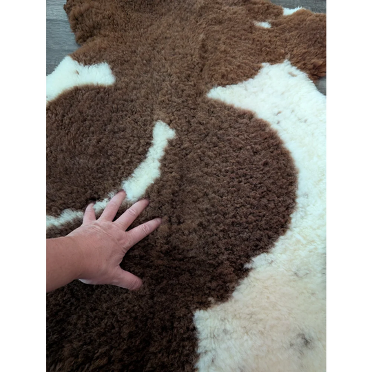 Brown and white tibet highland spotted sheepskin rug with a soft fluffy texture perfect for cozy decor