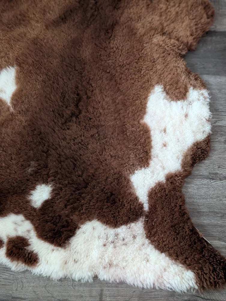 Brown and white tibet highland spotted sheepskin rug with soft plush faux fur texture 43 x 26 inches