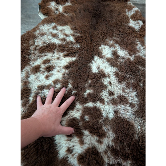 Brown and white plush tibet highland spotted sheepskin rug 41 by 25 inches with a soft fluffy texture