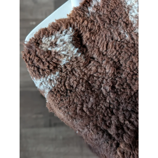 Brown and white fluffy fleece blanket made from grade a tibet highland spotted sheepskin with a soft textured surface