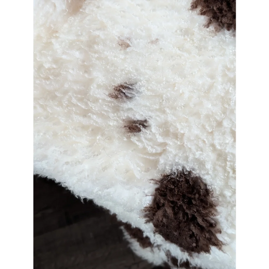 White and brown fluffy tibet highland spotted sheepskin with plush textured surface for cozy decor or rugs