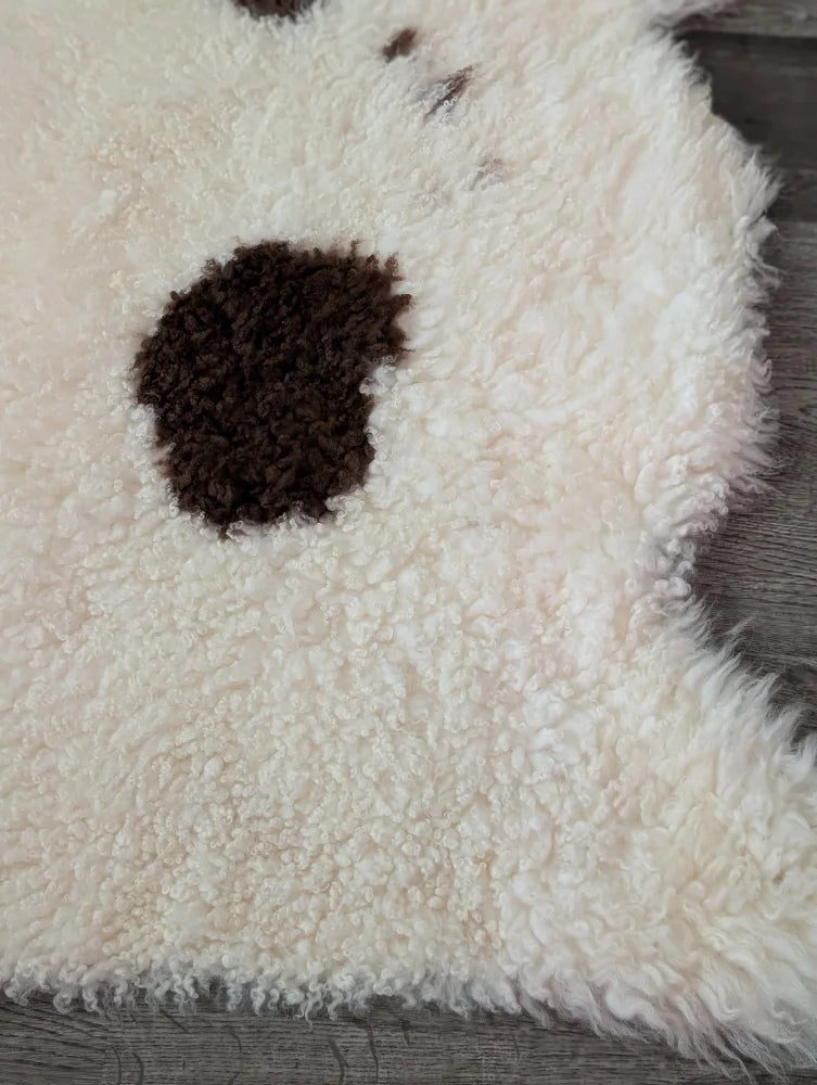 A cream highland spotted sheepskin rug with a dark brown spot from tibet highland spotted collection