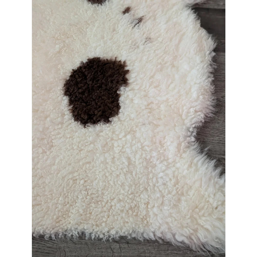 A cream highland spotted sheepskin rug with a dark brown spot from tibet highland spotted collection