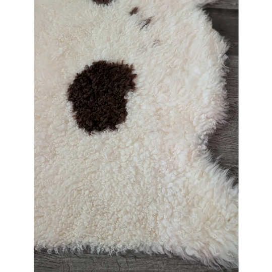 A cream highland spotted sheepskin rug with a dark brown spot from tibet highland spotted collection