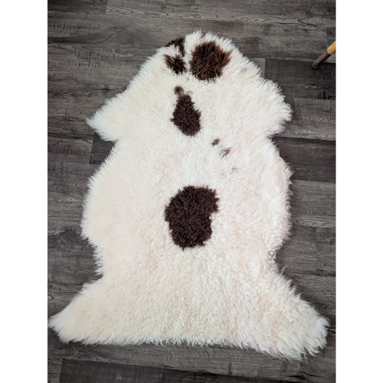 Fluffy white tibet highland spotted sheepskin rug with three dark brown patches in a vertical line 44 x 26 inches
