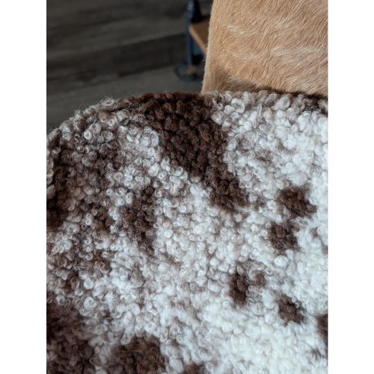 A cozy chunky knit blanket in soft white and brown mottled pattern made from tibet highland spotted sheepskin grade a