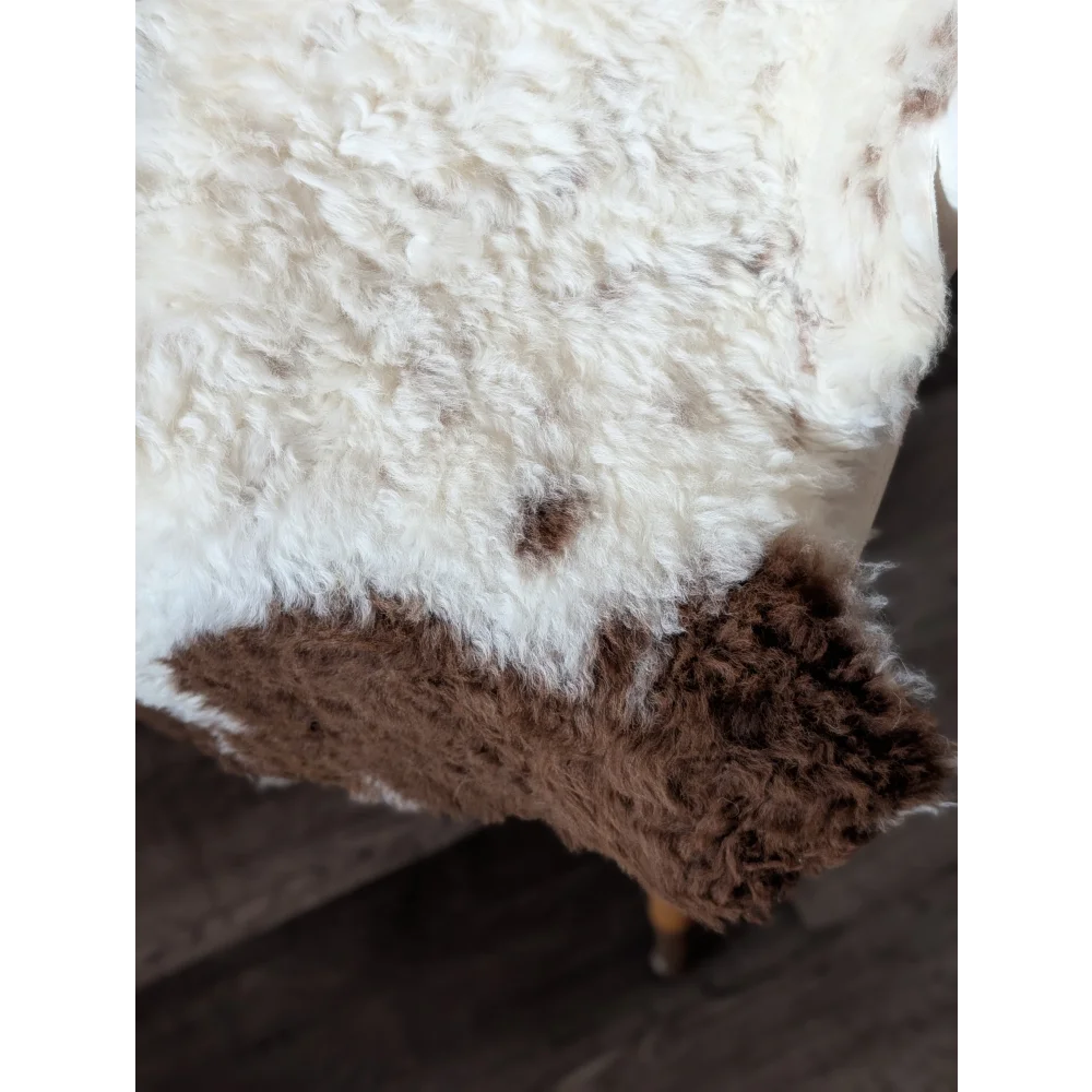 A plush tibet highland spotted sheepskin rug with soft white and brown fur measuring 39 by 25 inches