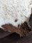 A plush tibet highland spotted sheepskin rug with soft white and brown fur measuring 39 by 25 inches