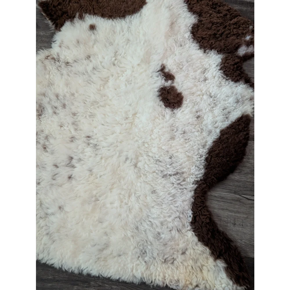A plush cream and brown tibet highland spotted sheepskin rug with a soft curly texture perfect for cozy spaces