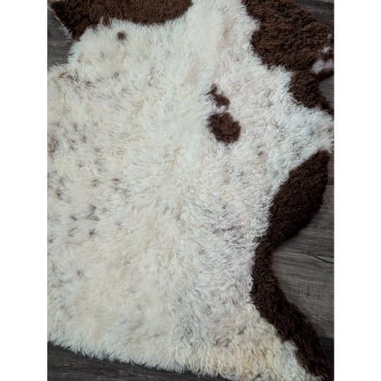 A plush cream and brown tibet highland spotted sheepskin rug with a soft curly texture perfect for cozy spaces