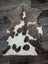 Brown and white tibet highland spotted sheepskin rug with fluffy natural texture measuring 40 by 25 inches