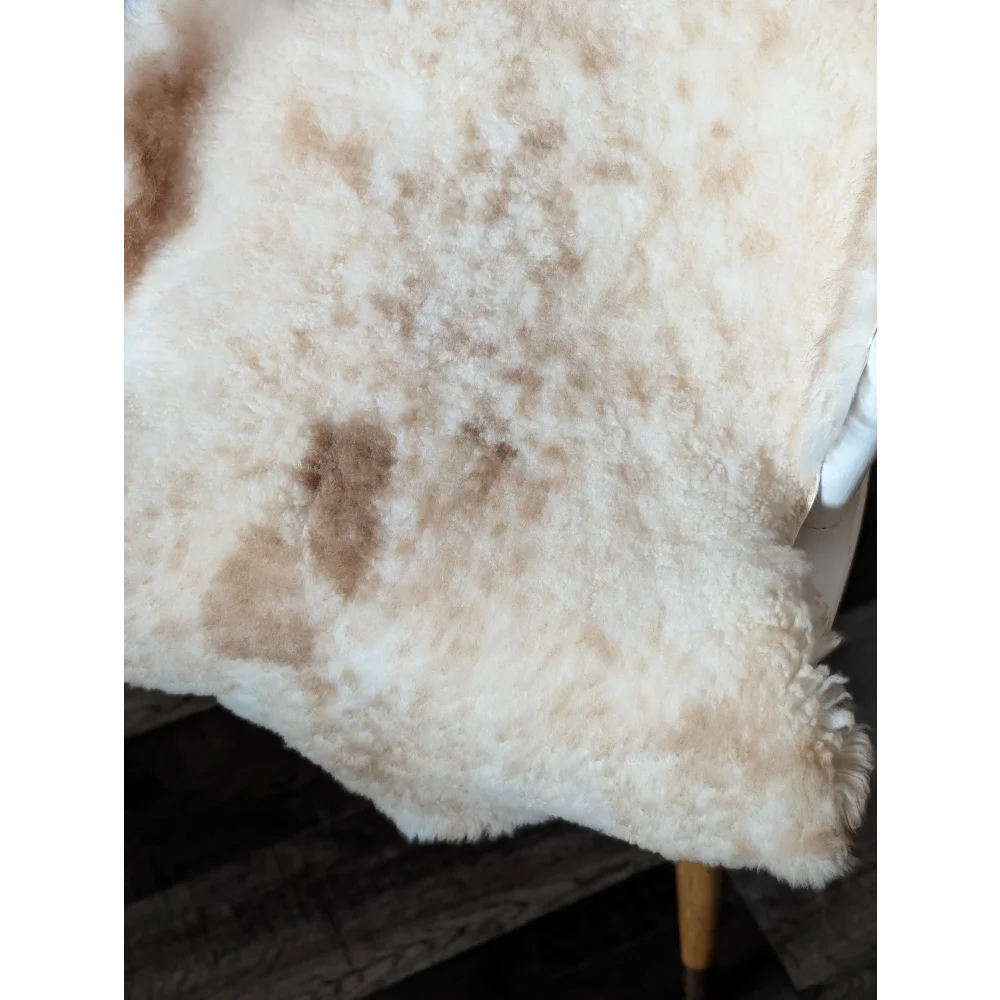 Cream-colored tibet highland spotted sheepskin blanket with soft fluffy texture and natural brown patches grade a quality