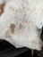 Cream-colored tibet highland spotted sheepskin blanket with soft fluffy texture and natural brown patches grade a quality