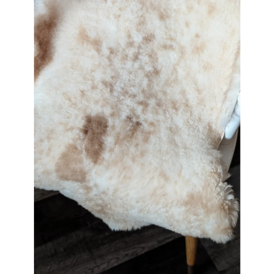 Cream-colored tibet highland spotted sheepskin blanket with soft fluffy texture and natural brown patches grade a quality