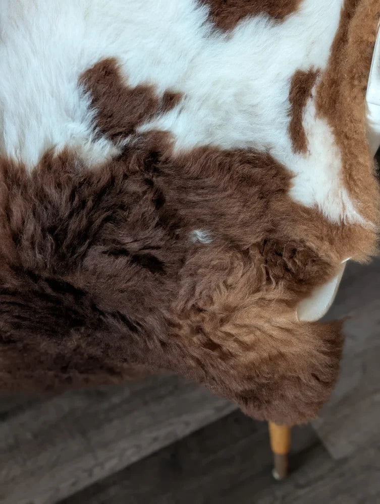Brown and white cow print faux fur throw blanket made from grade a tibet highland spotted sheepskin measuring 42 x 25 inches