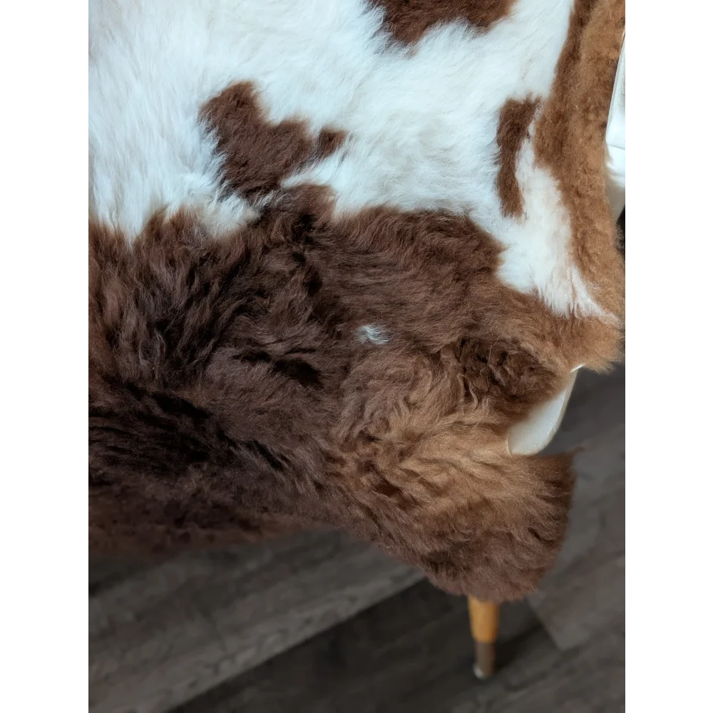 Brown and white cow print faux fur throw blanket made from grade a tibet highland spotted sheepskin measuring 42 x 25 inches