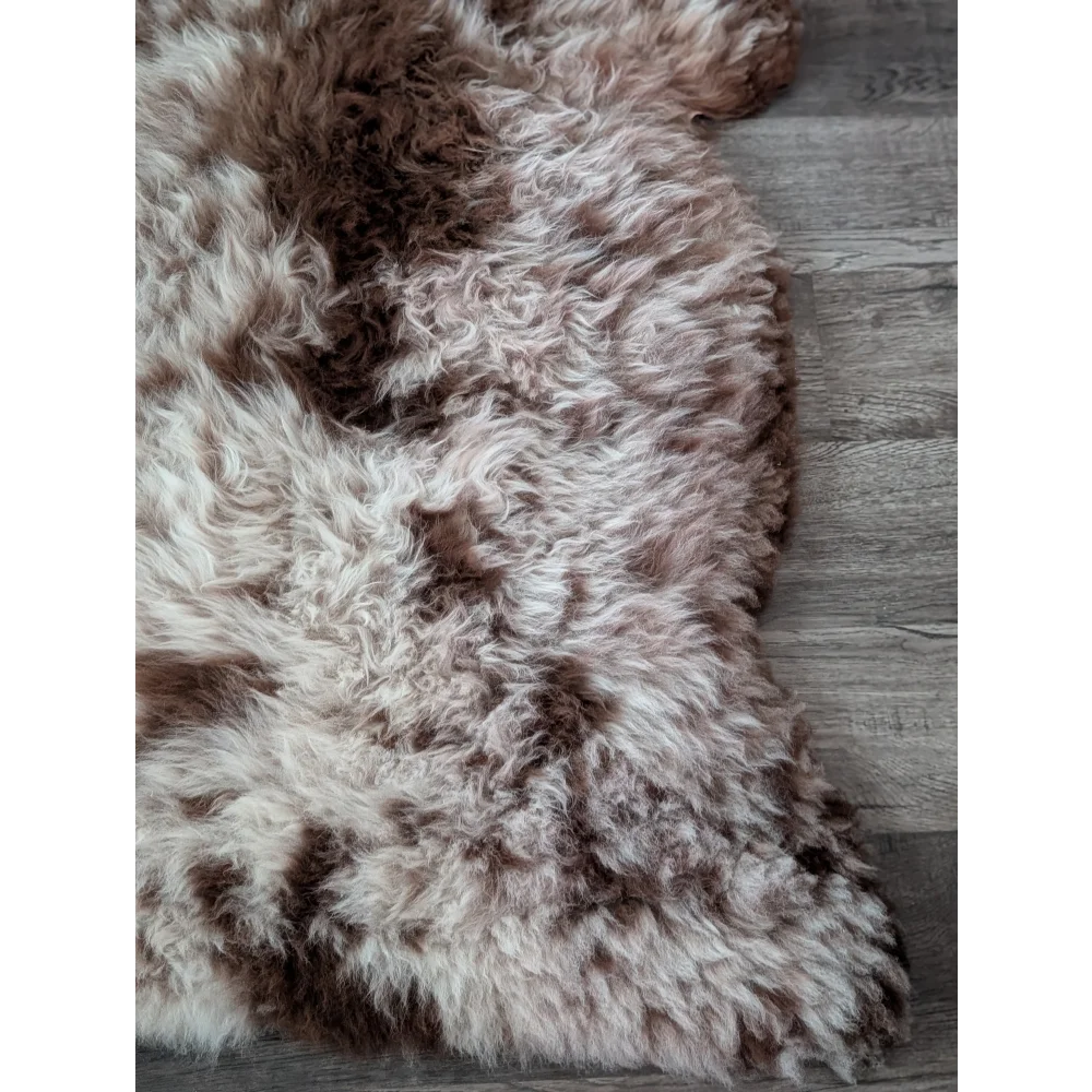 A plush cream and brown tibet highland spotted sheepskin rug 47 by 25 inches perfect for cozy decor
