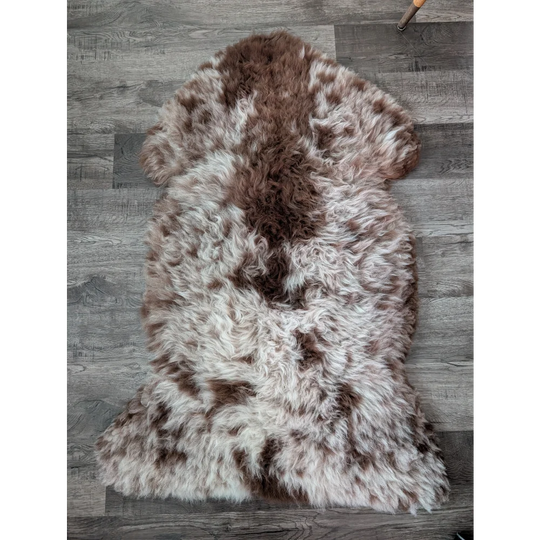 A gorgeous tibet highland spotted sheepskin rug with creamy white and rich brown fur, 47 by 25 inches